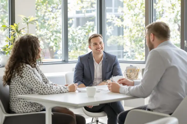 Consultant and client in a bright office discussing insurance.